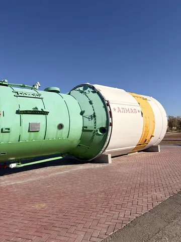 A green and white spacecraft module on display.